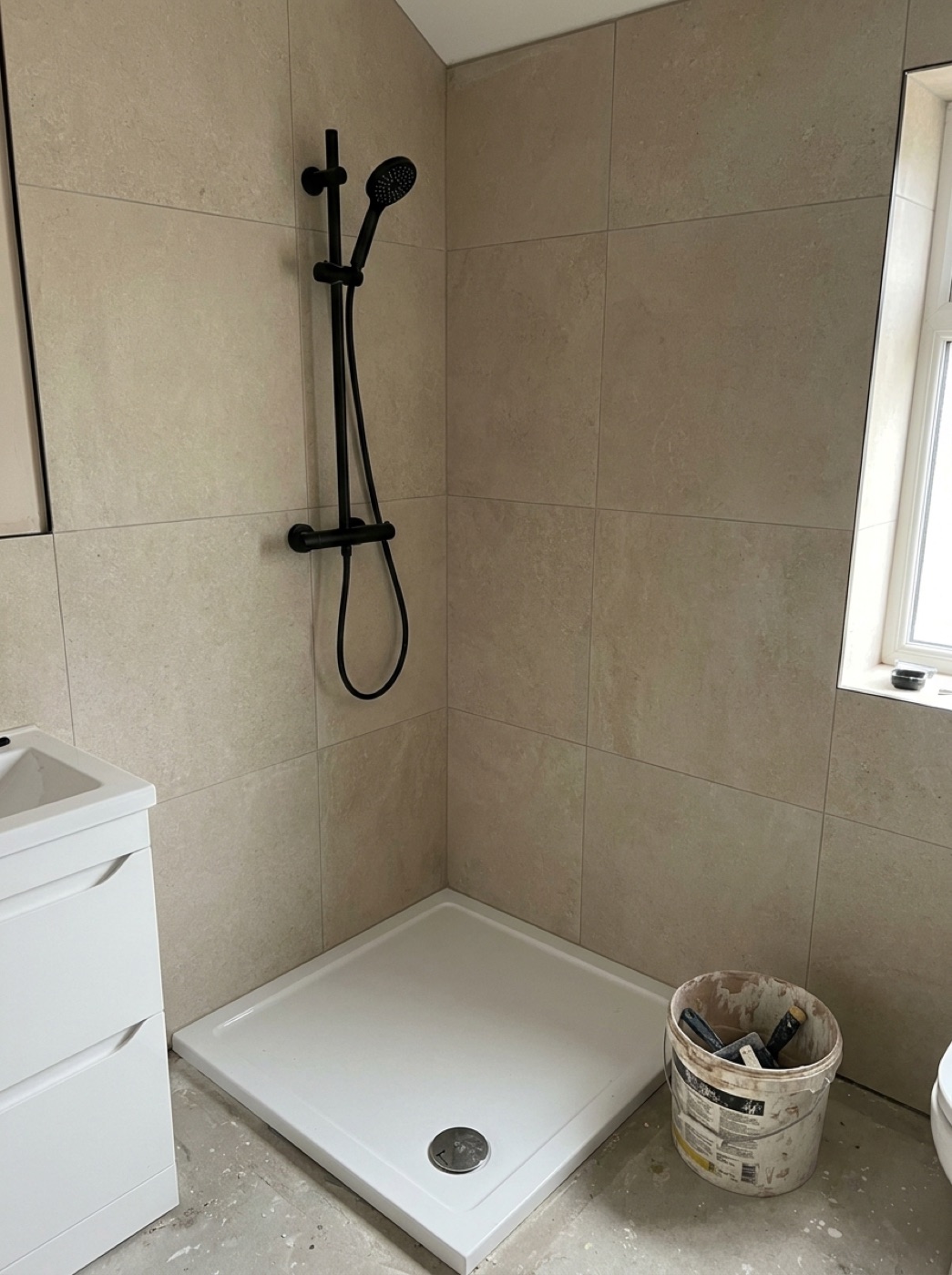 Cream stone-look large-format bathroom tiling with black tapware, Melbourne