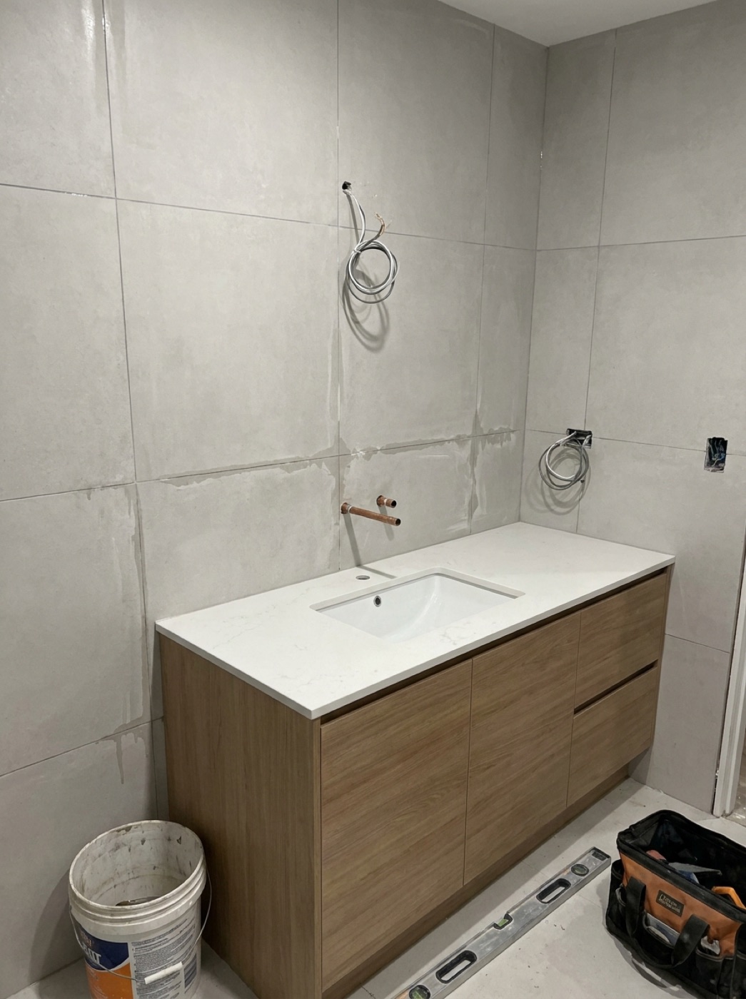 Double vanity bathroom with grey marble-look wall tiles and timber cabinetry